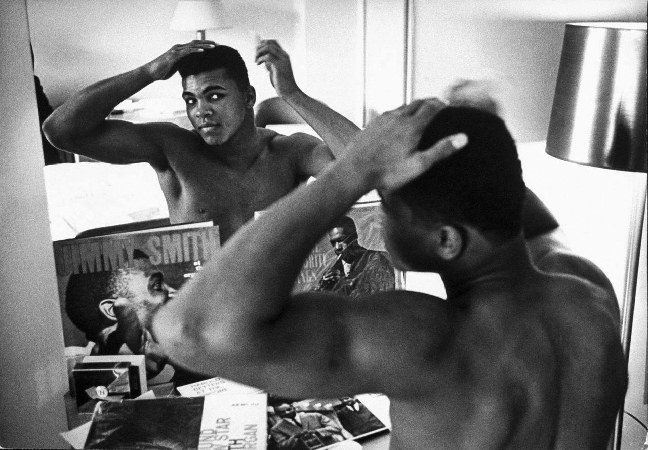 The boxing heavyweight contender then known as Cassius Clay combs his hair in the mirror in a Pittsburgh hotel room on Jan. 24, 1963.