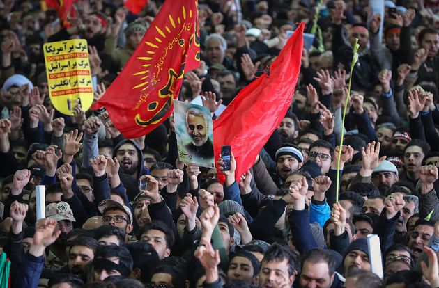 Iranian mourners carry a picture of Iran's supreme leader Ayatollah Ali Khamenei Qassem Soleimani during the funeral procession in the capital