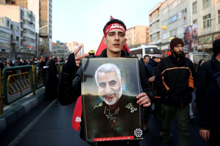 An Iranian man holds a picture of Qassem Soleimani during a funeral procession for Iranian Major-General Qassem Soleimani, head of the elite Quds Force, and Iraqi militia commander Abu Mahdi al-Muhandis, who were killed in an air strike at Baghdad airport, in Tehran, Iran January 6, 2020.