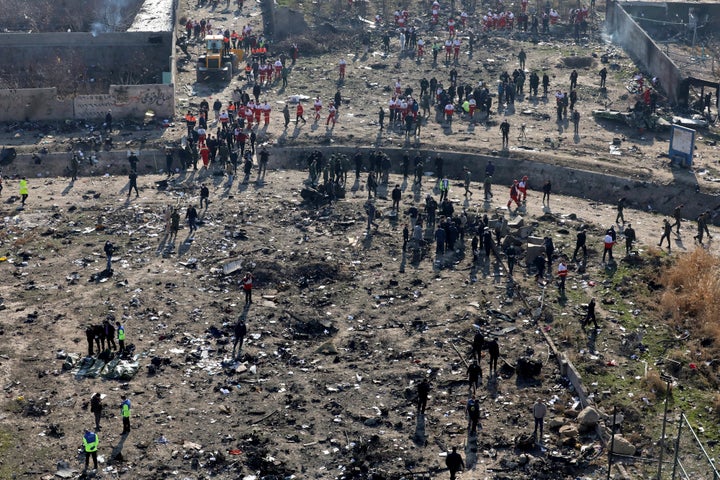 Rescue workers search the scene of the crash