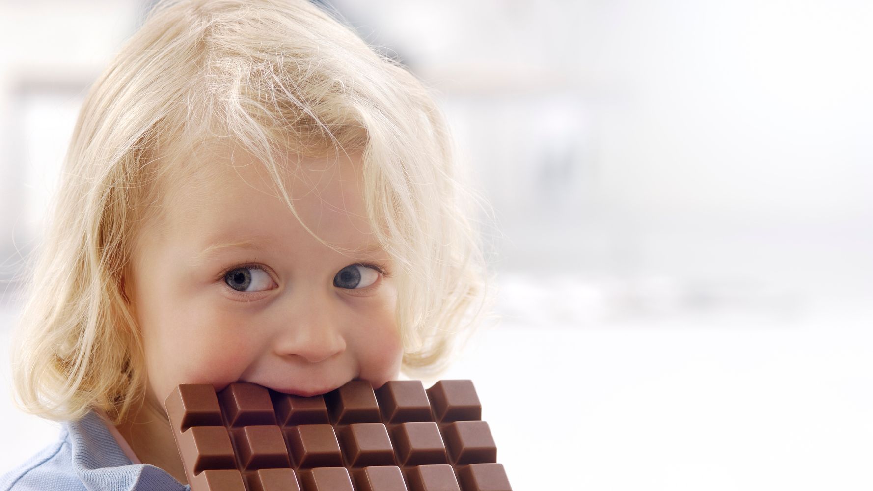 Мальчик с шоколадкой. Ребенок ест шоколад. Счастливый ребенок с шоколадом.