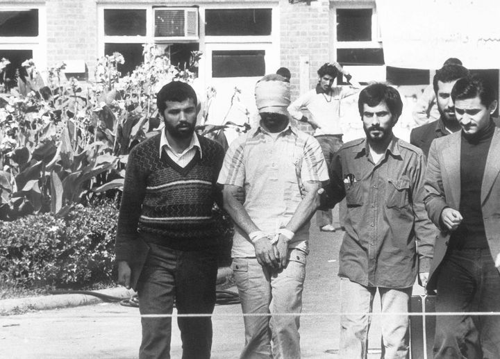 A hostage held at the US embassy in Tehran is shown to the crowd by Iranian students on November 8, 1979