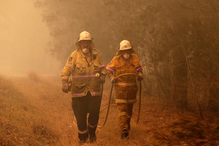 New South Wales firefighters drag their water hose after putting out a spot fire on the state's south coast.