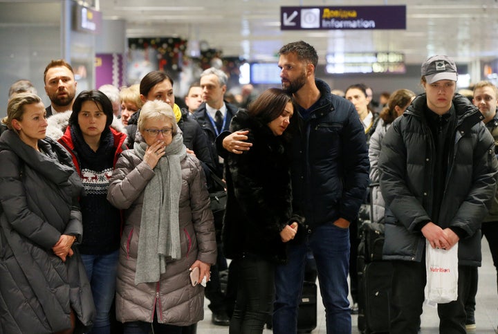 People react in front of a memorial Jan. 8, 2020. for the flight crew members of the Ukraine International Airlines Boeing 737-800 plane that crashed in Iran.