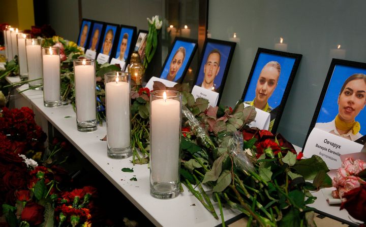 Flowers and candles are placed in front of portraits of the flight crew members of the Ukrainian 737-800 plane.