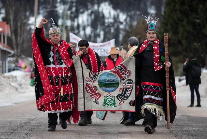 Heredity Chiefs Madeek (left) and Namoks carry a flag while leading a solidarity march to show support for the Wet'suwet'en Nation, in Smithers, B.C. on Jan. 16, 2019.