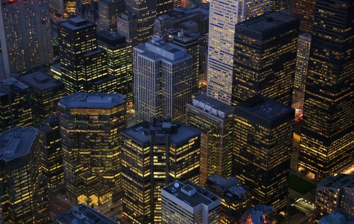 A night-time view of illuminated skyscrapers in the financial district of Toronto.