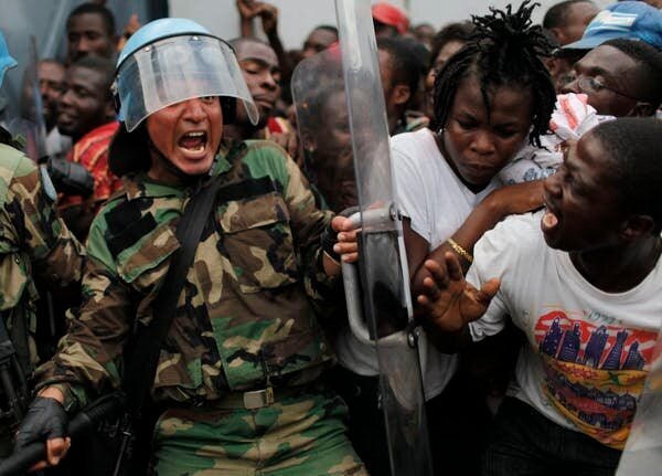 Un casque bleu péruvien tente de contrôler une foule pendant la distribution de nourriture pour les survivants du tremblement de terre dans un entrepôt à Port-au-Prince, le 19 janvier 2010. L’aide de l’ONU a été globalement inefficace.