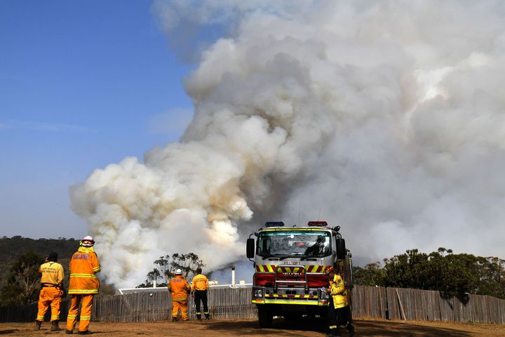Firefighters work as smoke rises from a bushfire in Penrose, in Australia's New South Wales state on January 10, 2020.