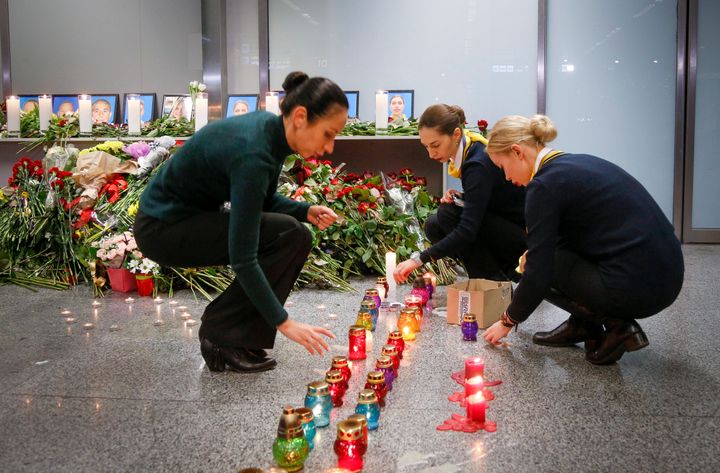 Colleagues of the flight crew members of the Ukrainian 737-800 plane that crashed on the outskirts of Tehran, light candles at a memorial inside Borispil international airport outside Kyiv, Ukraine, Wednesday.