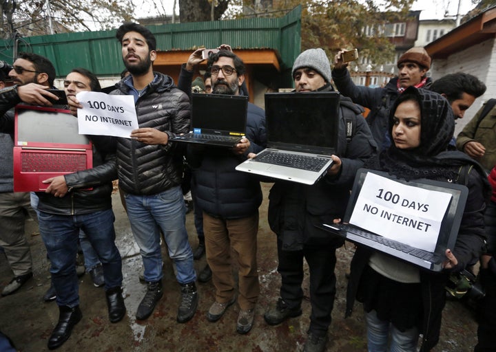 Kashmiri journalists display laptops and placards during a protest demanding restoration of internet service, in Srinagar, No