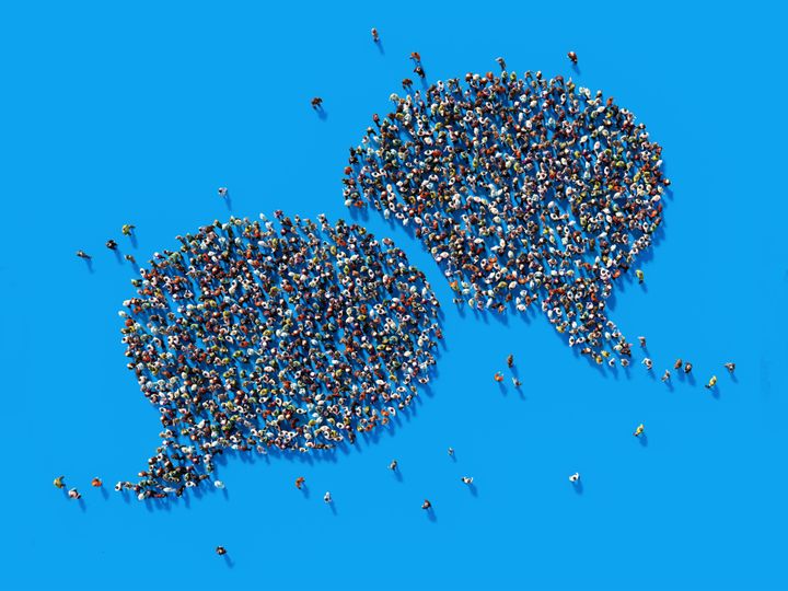 Human crowd forming a big speech bubble on blue background. Horizontal composition with copy space. Clipping path is included. Communication And Social Media Concept.