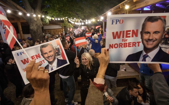 Supporters of the far-right Freedom Party hold campaign posters featuring their party leader Norbert Hofer during a September political event. The new government coalition has pushed back on the Freedom Party.