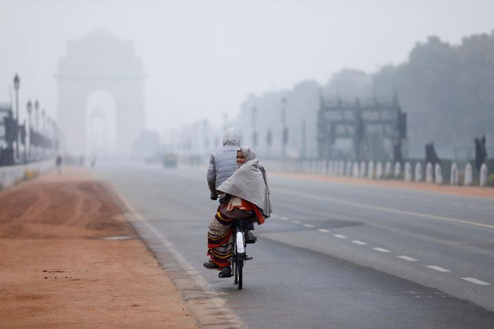 File photo of a woman sitting behind a bicycle on a cold winter morning in New Delhi.