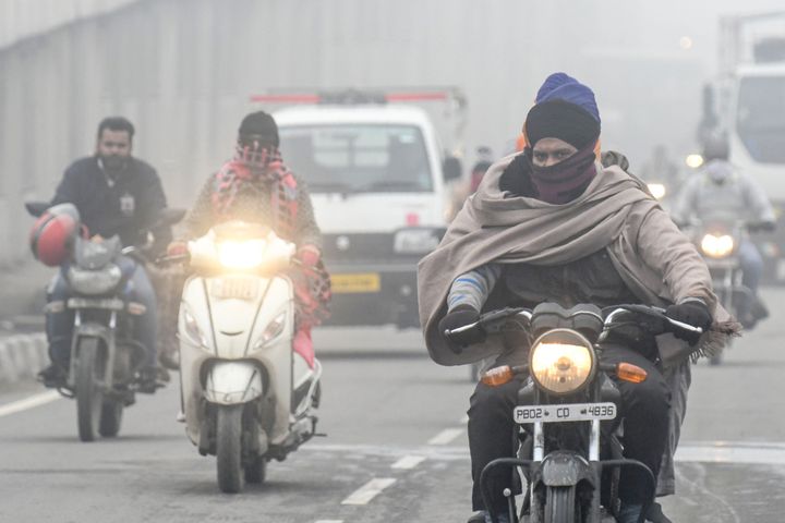 Commuters make their way on a road under heavy foggy conditions in Amritsar on January 9, 2020. 