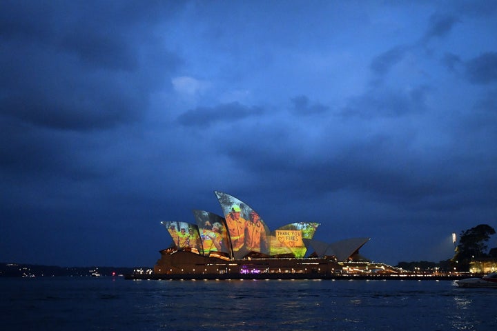 The sails of the Opera House are lit with a series of images to show support for the communities affected by the bushfires and to express the gratitude to the emergency services and volunteers in Sydney on January 11, 2020. - Massive bushfires in southeastern Australia have a "long way to go", authorities have warned, even as colder conditions brought some relief to exhausted firefighter and communities. (Photo by SAEED KHAN / AFP) (Photo by SAEED KHAN/AFP via Getty Images)