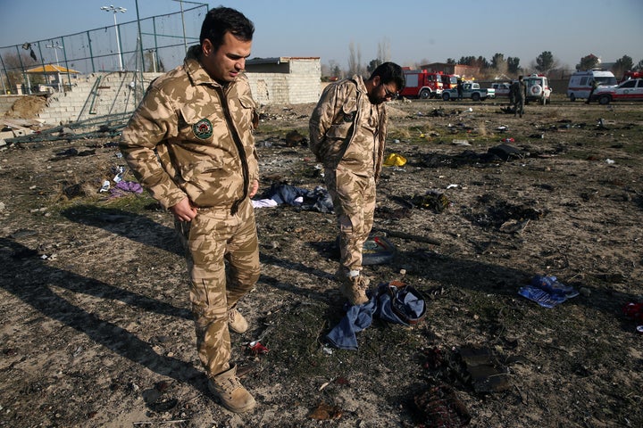 Security look at passengers' belongings at the site where the Ukraine International Airlines plane crashed in Iran on Jan. 8, 2020. 