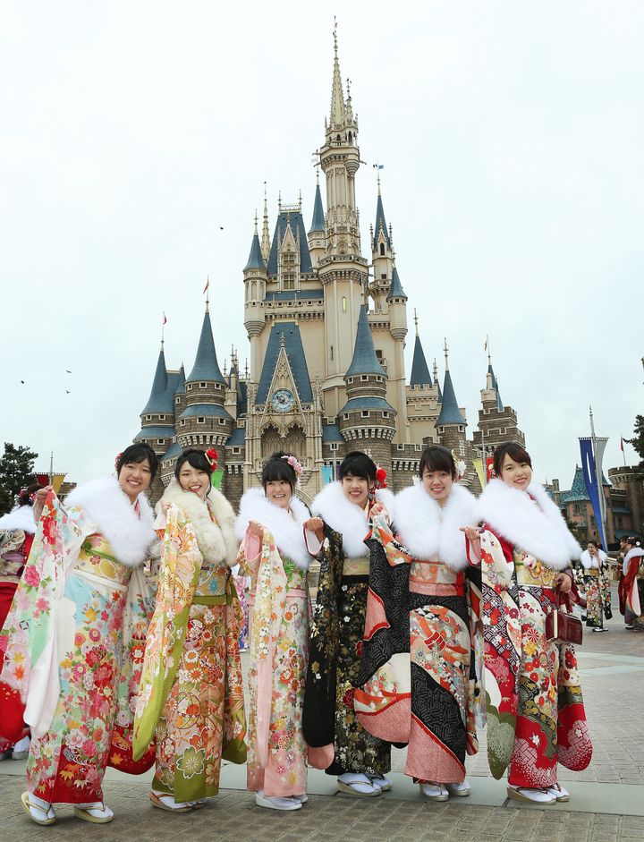 東京ディズニーランド（ＴＤＬ）で成人式が行われ、シンデレラ城を背に晴れ着姿を披露する新成人＝2018年1月8日、千葉県浦安市