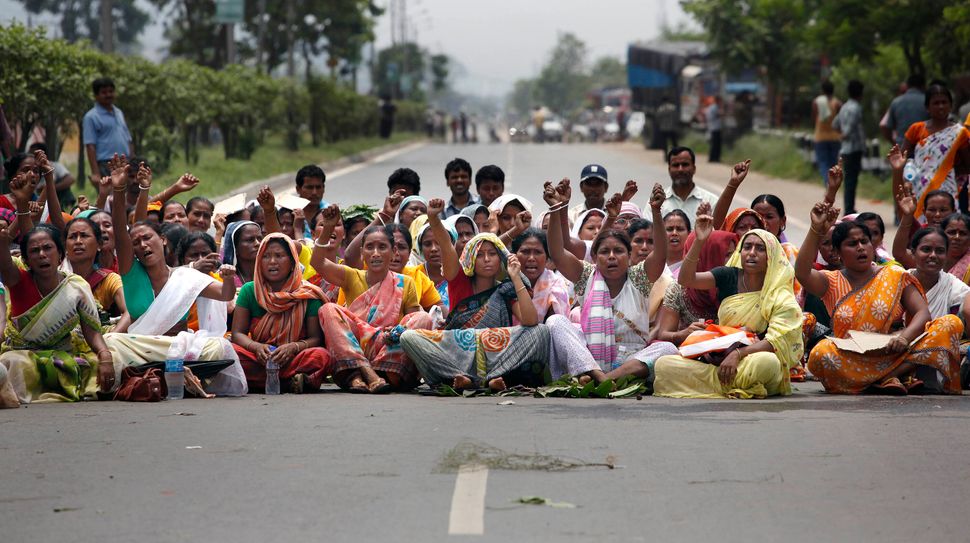 Evicted people from nearby hills, who were living in the forest area for years, block a national highway during the 12-hour general strike in protest against the arrest of Akhil Gogoi, June 25, 2011. Gogoi was fighting for the rights of the evicted people. 