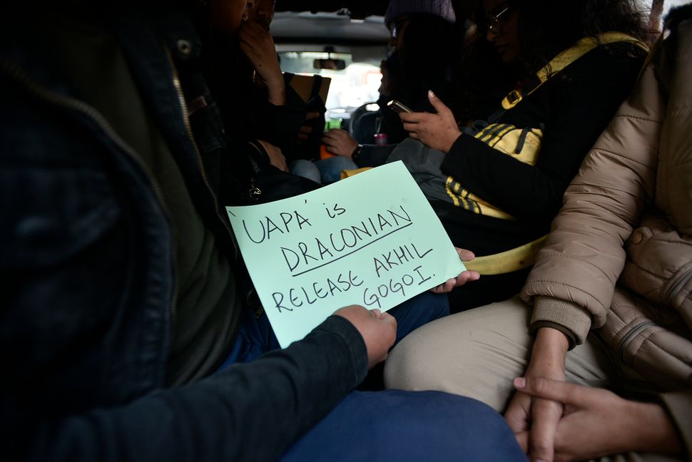 A protester holds a placard after being detained by Delhi Police during a protest against Citizenship Amendment Act (CAA) and the release of Akhil Gogoi, outside Assam Bhawan, on December 23, 2019 in New Delhi.