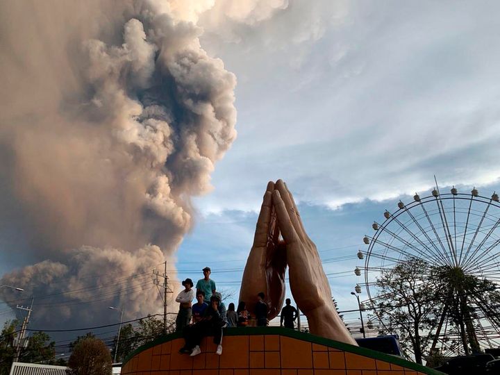 People watch as the Taal volcano spews ash and smoke during an eruption in Tagaytay, Cavite province south of Manila, Philippines on Sunday. 