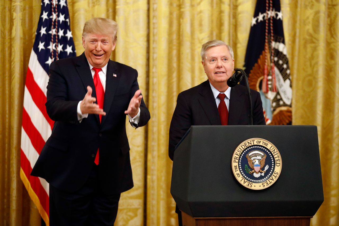 President Donald Trump gestures as Sen. Lindsey Graham (R-S.C.) speaks in the East Room of the White House on Nov. 6, 2019. Graham has become one of Trump's leading GOP apologists.