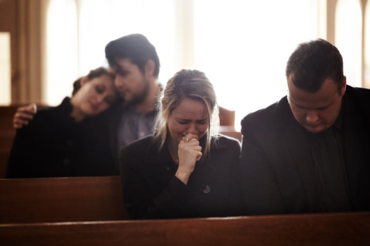 people crying at a funeral