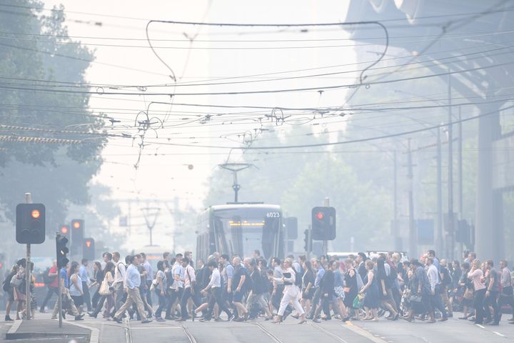 Morning commuters are seen through smoke haze from bushfires in Melbourne. 