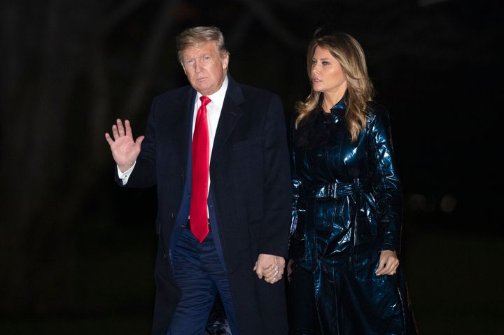 President Donald Trump with first lady Melania Trump waves as they arrive back to the White House early Tuesday following a trip to watch the College Football Playoff national championship game in New Orleans.