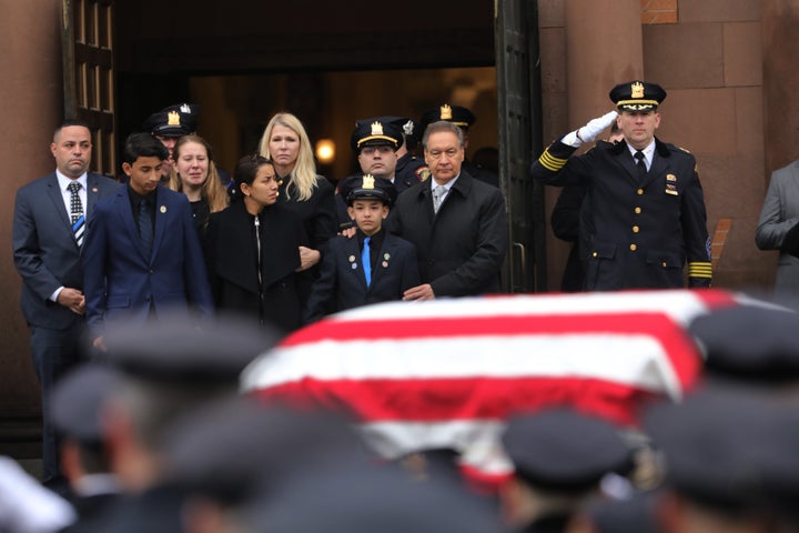 Family members watch as the casket for New Jersey Detective Joseph Seals is brought out of a church during his funeral on December 17, 2019 in Jersey City, New Jersey.
