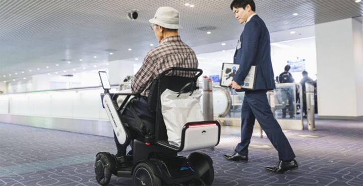 2019年11月に羽田空港で行われた実験の様子。自動運転技術を搭載した『WHILL』によって搭乗口まで案内を行った。2020年内には、世界の大型空港において車椅子移動サービスの提供開始を目指す。現在日本をはじめアメリカ、UAE、カナダ、オランダなど世界で実験中。