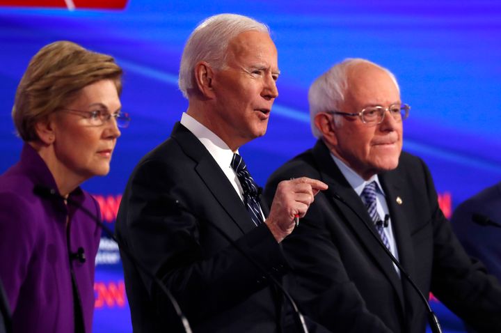 Sens. Elizabeth Warren (D-Mass.) and Bernie Sanders (I-Vt.) listen as former Vice President Joe Biden speaks during the Democ