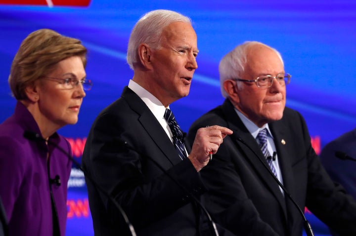 Sens. Elizabeth Warren (D-Mass.) and Bernie Sanders (I-Vt.) listen as former Vice President Joe Biden speaks during the Democratic presidential debate at Drake University in Des Moines, Iowa, on Tuesday