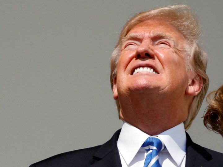 President Donald Trump looks toward the solar eclipse without his protective glasses from the Truman balcony of the White House.