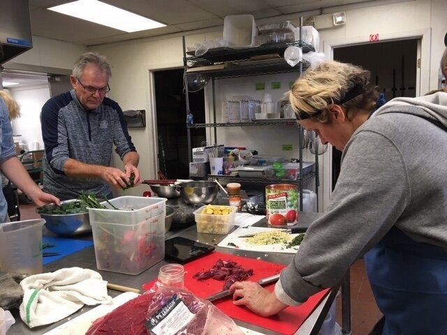 A group participates in a collective cooking party organized by Eat for Equity.