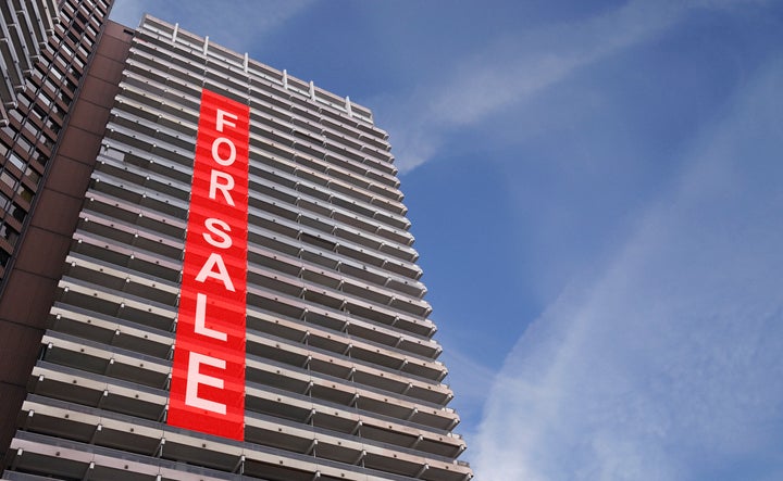 A stock photo of a for-sale sign on a condo building.