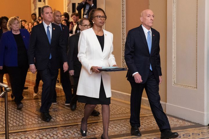 House sergeant at arms Paul Irving and clerk of the House Cheryl Johnson carry the articles of impeachment on Capitol Hill in Washington.