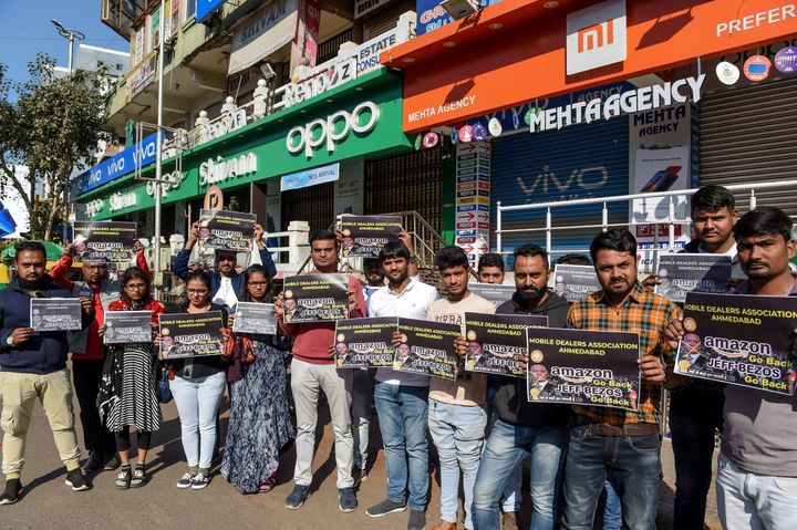 Mobile dealers and members of Ahmedabad Mobile Dealer's Association hold placards as they protest against Amazon in Ahmedabad on January 15, 2020.