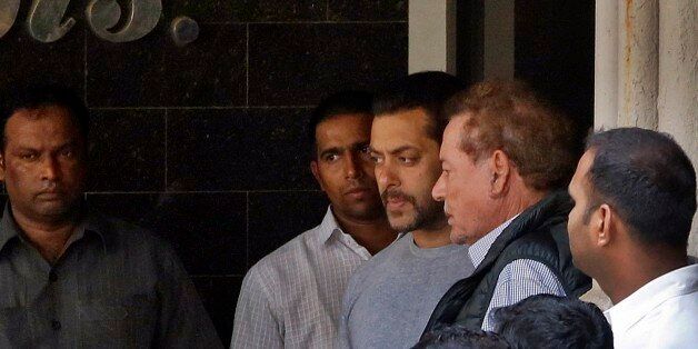 Bollywood actor Salman Khan, center, and his father Salim Khan, second right, come out of their residence to see off a guest in Mumbai, India, Thursday, May 7, 2015. One of India's biggest and most popular movie stars, Khan, was sentenced to five years in jail Wednesday on charges of driving a vehicle over five men sleeping on a sidewalk and killing one in a hit-and-run case that has dragged for more than 12 years. (AP Photo/Rajanish Kakade)