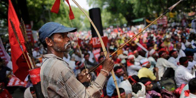 An Indian farmer holds a bow and an arrow as he attends a gathering near the Indian parliament for a protest against the Land Acquisition Bill, in New Delhi, India, Tuesday, May 5, 2015. Indian farmers protested against the ruling Bharatiya Janata Partyâs Land Acquisition Bill, calling it anti-farmer in a country where agriculture is the main livelihood for more than 60 percent of the 1.2 billion people. (AP Photo/Altaf Qadri)