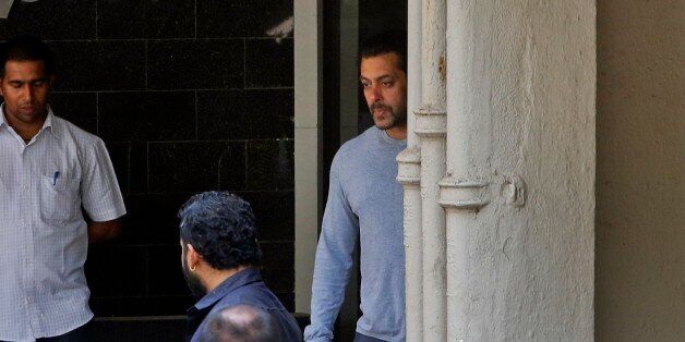 Bollywood actor Salman Khan, center, comes out of his residence to see off a guest in Mumbai, India, Thursday, May 7, 2015. One of India's biggest and most popular movie stars, Khan, was sentenced to five years in jail Wednesday on charges of driving a vehicle over five men sleeping on a sidewalk and killing one in a hit-and-run case that has dragged for more than 12 years. (AP Photo/Rajanish Kakade)