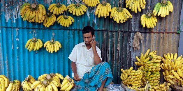 A Bangladeshi banana vendor talks on his mobile phone in Dhaka, Bangladesh, Monday, June 10, 2013. (AP Photo/A.M.Ahad)
