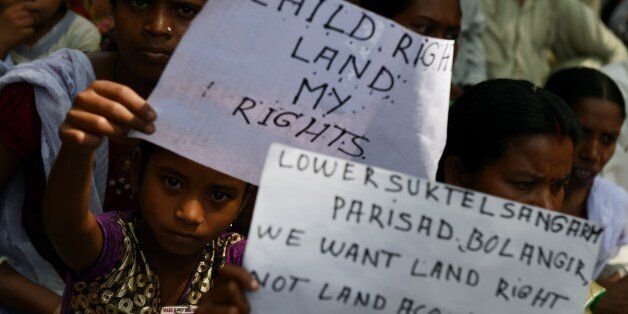 Indian protestors are joined by children holding placards during a rally in New Delhi on May 5, 2015, against the ruling governments proposed land acquisition bill. Anger has also been mounting in rural Indian areas over Prime Minister Narendra Modi's land reform bill, which the government says is needed speed up economic growth, but political opponents say favours big business at the expense of struggling farmers. AFP PHOTO/MONEY SHARMA. (Photo credit should read MONEY SHARMA/AFP/Ge
