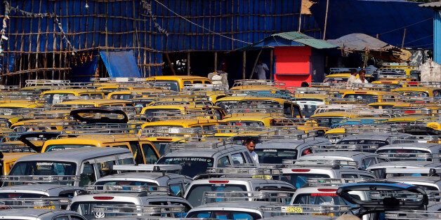 In this Tuesday, March 25, 2014 photo, traditional black-and-yellow licensed cabs and private cabs stand at a parking lot at the airport in Mumbai, India. Taxi-hailing smartphone app Uber is making a big push into Asia with the company starting operations in 18 cities in Asia and the South Pacific including Seoul, Shanghai, Bangkok, Hong Kong and five Indian cities in the last year. (AP Photo/Rajanish Kakade)