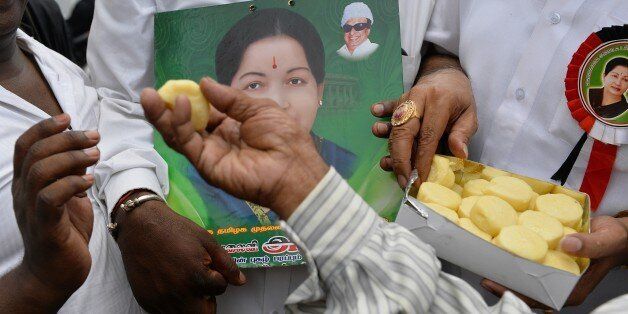 Supporters of All India Anna Dravida Munnetra Kazhagam (AIADMK) supremo, Jayalalithaa Jayaram distribute sweets as they hear the news of the acquital of their leader in the 18-year-old, disproportionate assets case in Bangalore on May 11, 2015. The head of India's largest Tamil party was cleared of corruption May 11, 2015, a verdict that sparked wild celebrations by supporters and paved the way for the return of one of the country's most powerful politicians. AFP PHOTO/ Manjunath KIRAN