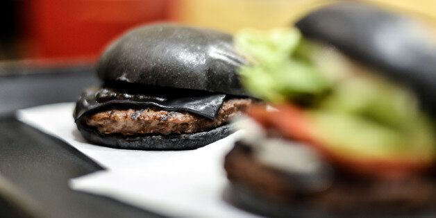 TOKYO, JAPAN - SEPTEMBER 18: Black hamburgers are seen at a Burger King restaurant on September 18, 2014 in Tokyo, Japan. The black burgers, one a Kuro Pearl at 480 yen, has black buns and cheese smoked with bamboo charcoal and black sauce made of squid ink. The other, the Kuro Diamond at 690 yen, comes also with lettuce, tomato, onion and mayonnaise. The burgers are available from September 19 through early November in Burger King restaurants throughout Japan. (Photo by Keith Tsuji/Getty Imag