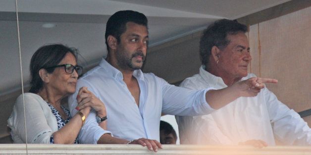 Bollywood actor Salman Khan gestures to fans from the balcony of his home, flanked by his mother Sushila Charak and father Salim Khan in Mumbai, India, Friday, May 8, 2015. A court on Friday granted bail to Khan, one of India's biggest movie stars until it hears his appeal challenging his conviction in a drunk-driving hit-and-run case more than a decade ago.