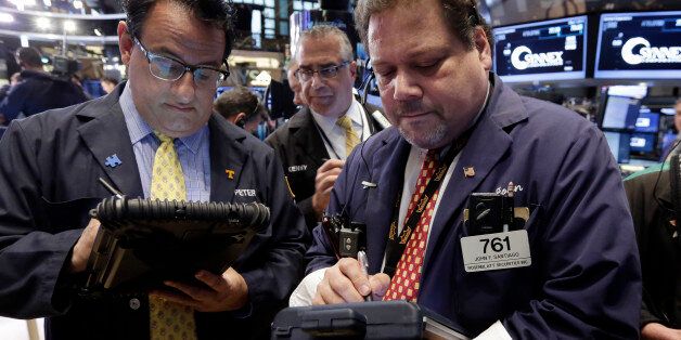 Traders Peter Costa, Kenneth Polcari, and John Santiago, left to right, work on the floor of the New York Stock Exchange Thursday, May 7, 2015. U.S. stocks are opening mostly lower, pushing the Dow Jones industrial average into the red for the year. (AP Photo/Richard Drew)