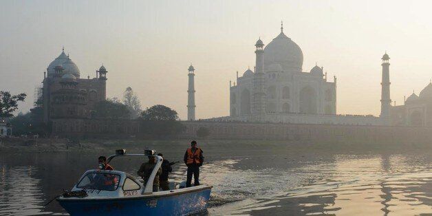 The historic Taj Mahal monument is pictured as a police patrol boat moves over the Yamuna river in Agra on January 18, 2015. Known as a 'monument to love' the Taj Mahal is a mausoleum built by Mughal Emperor Shah Jahan in memory of his favorite wife, Mumtaz Mahal. Construction of the Taj Mahal began around 1632, was completed around 1653 and is considered one of the finest examples of Mughal architecture - a style which combines Indian, Islamic and Persian elements. AFP PHOTO/STR (Photo credit should read STRDEL/AFP/Getty Images)