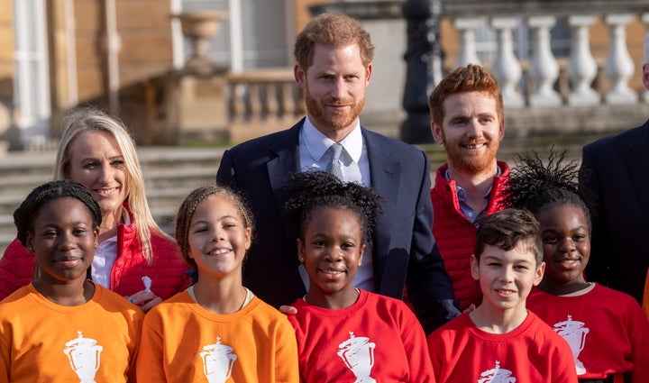 Harry poses with children from a local school after watching them play rugby in the Buckingham Palace gardens before the Rugby League World Cup 2021 draws for the men's, women's and wheelchair tournaments on Jan. 16.